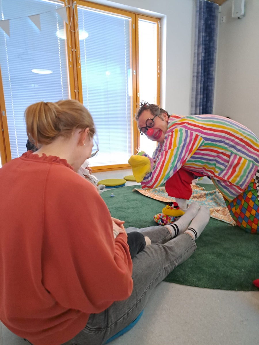 Klovni Moo leikkii perheen kanssa käsinukella